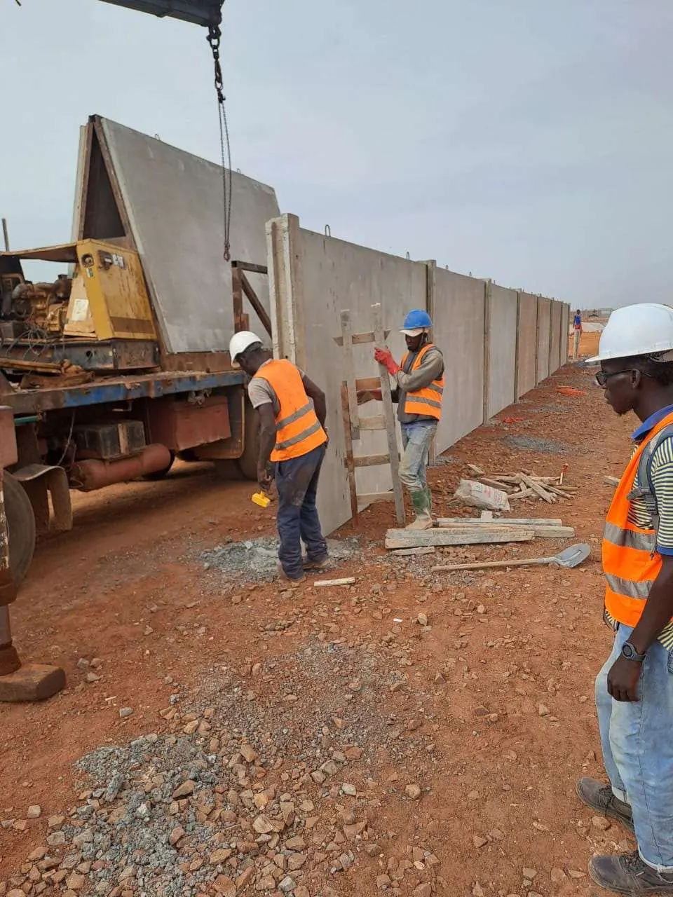 Pose des panneaux du mur de clôture à la grue